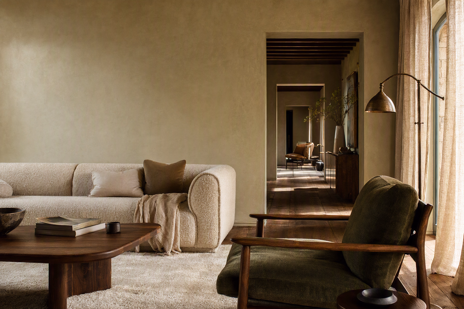 Layered living room composed with warm timber, tactile upholstery, and soft natural light