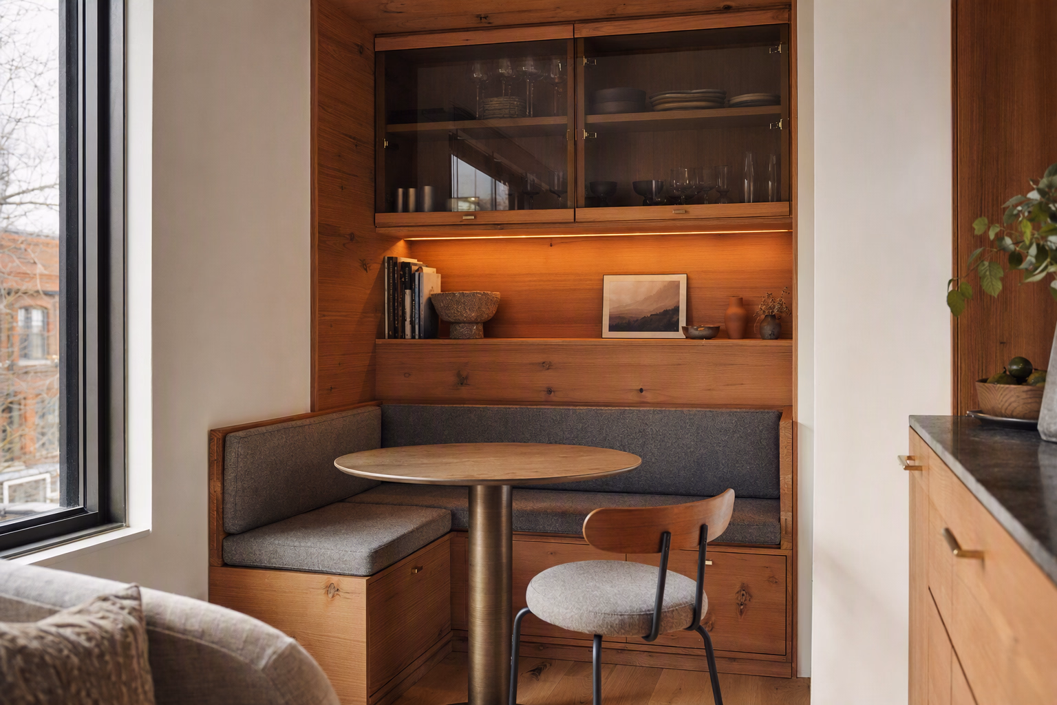 Compact dining area framed by cedar storage and softly reflective glass