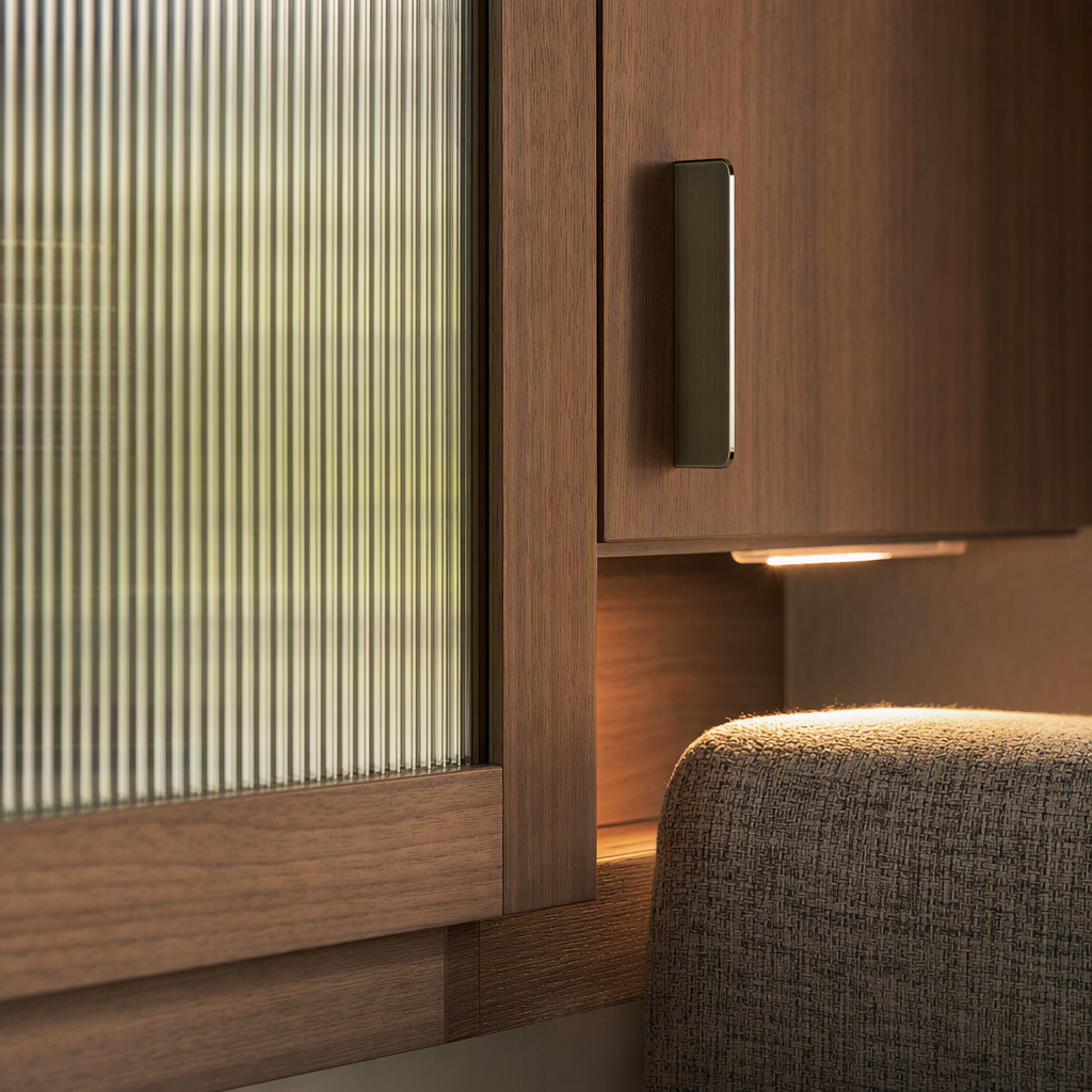 Close detail of cedar millwork, smoked glass, wool textile, and brushed metal hardware