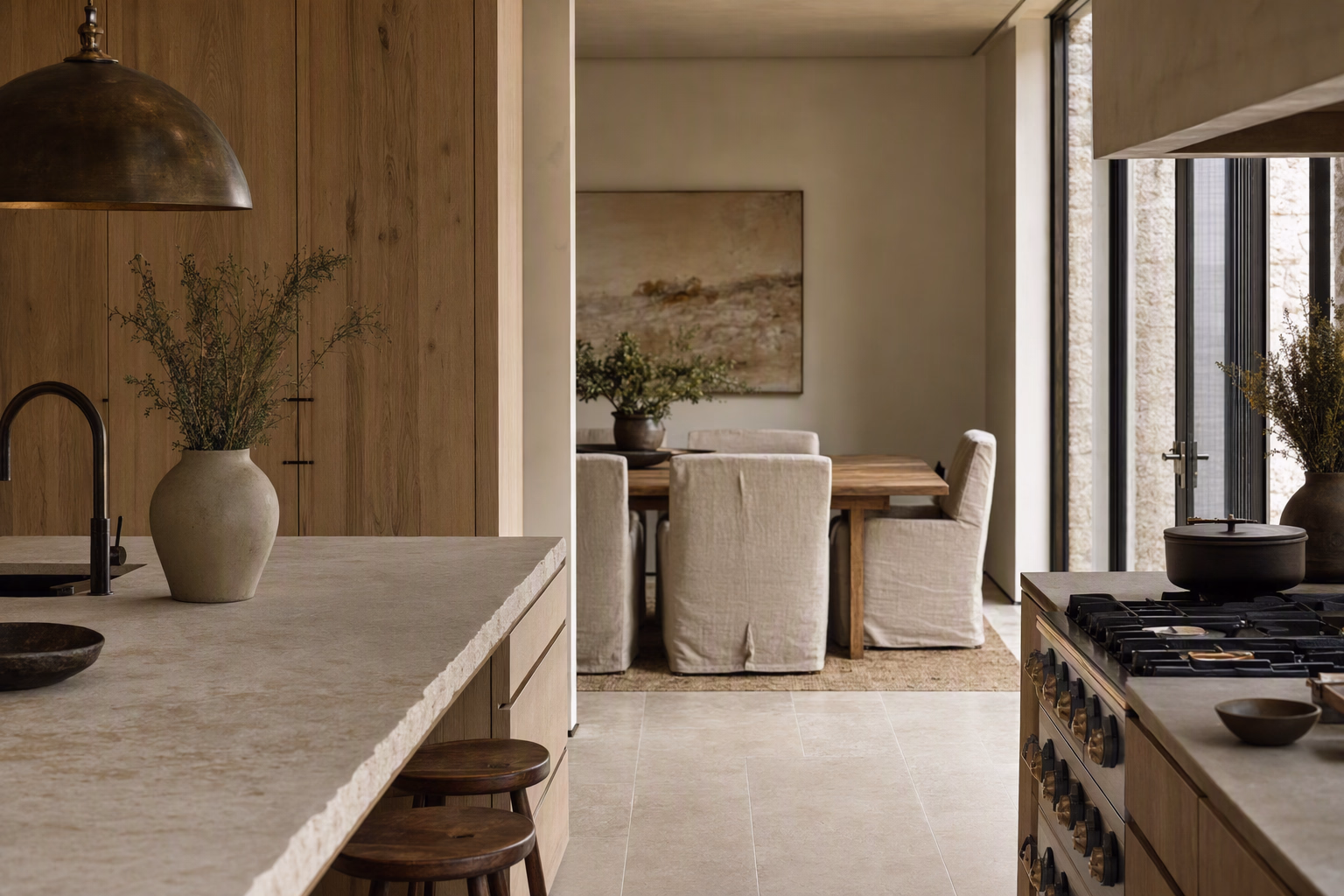 Pale oak kitchen opening directly into a limestone dining area